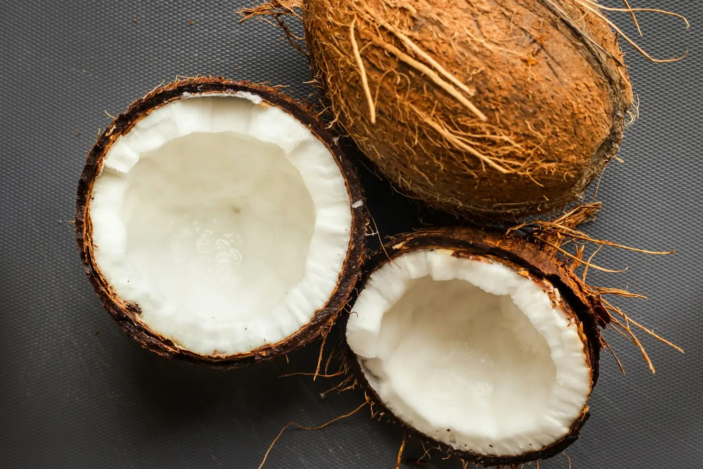 Halved mature coconuts showing thick white kernel